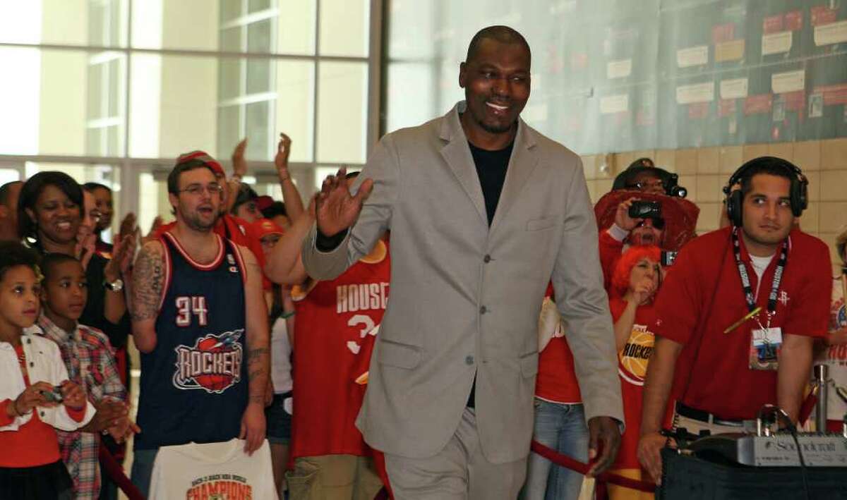 Former Houston Rockets player Hakeem Olajuwon waves to fans before the unveiling of a mural with the Houston Rockets team of the 1990s on Thursday, March 22, 2012, at the Toyota Center.
