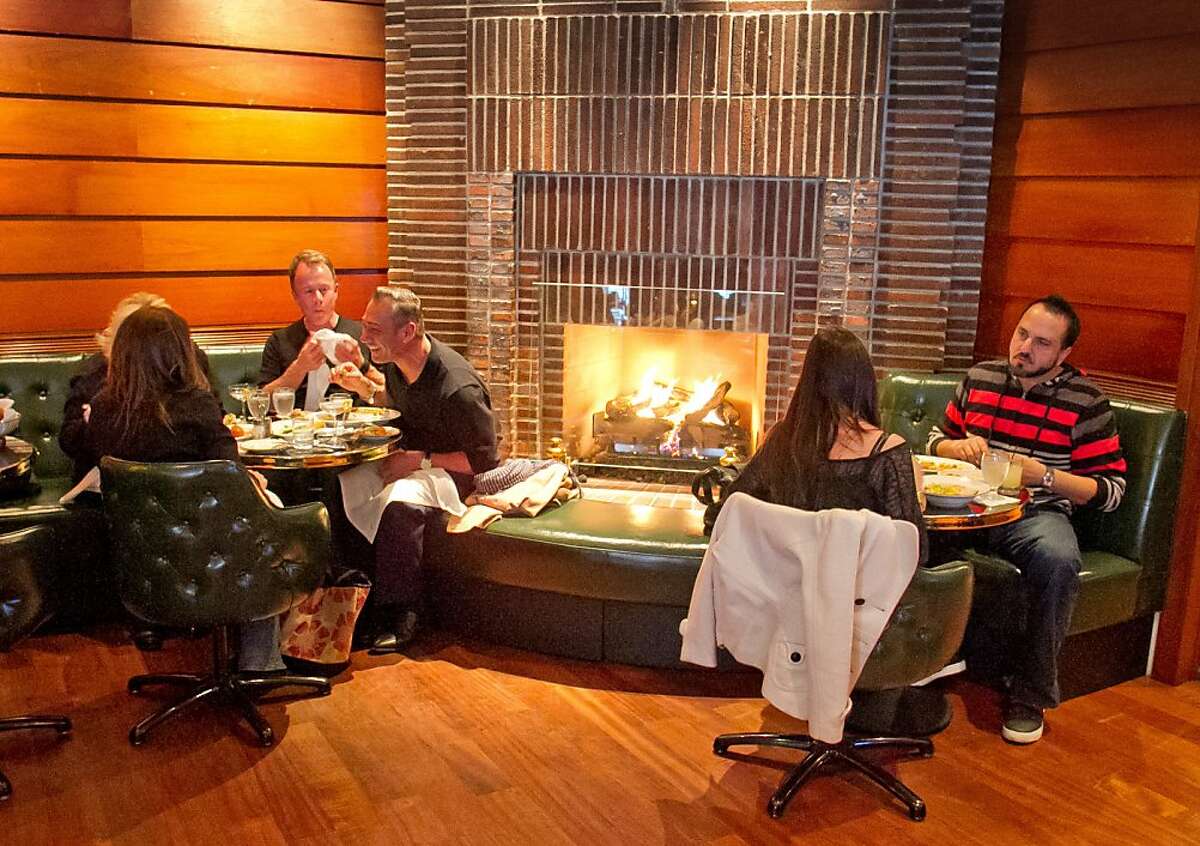 Diners enjoy dinner in front of the fireplace in the bar at Original Joe's Restaurant in San Francisco, Calif., on Tuesday, March 20th, 2012.