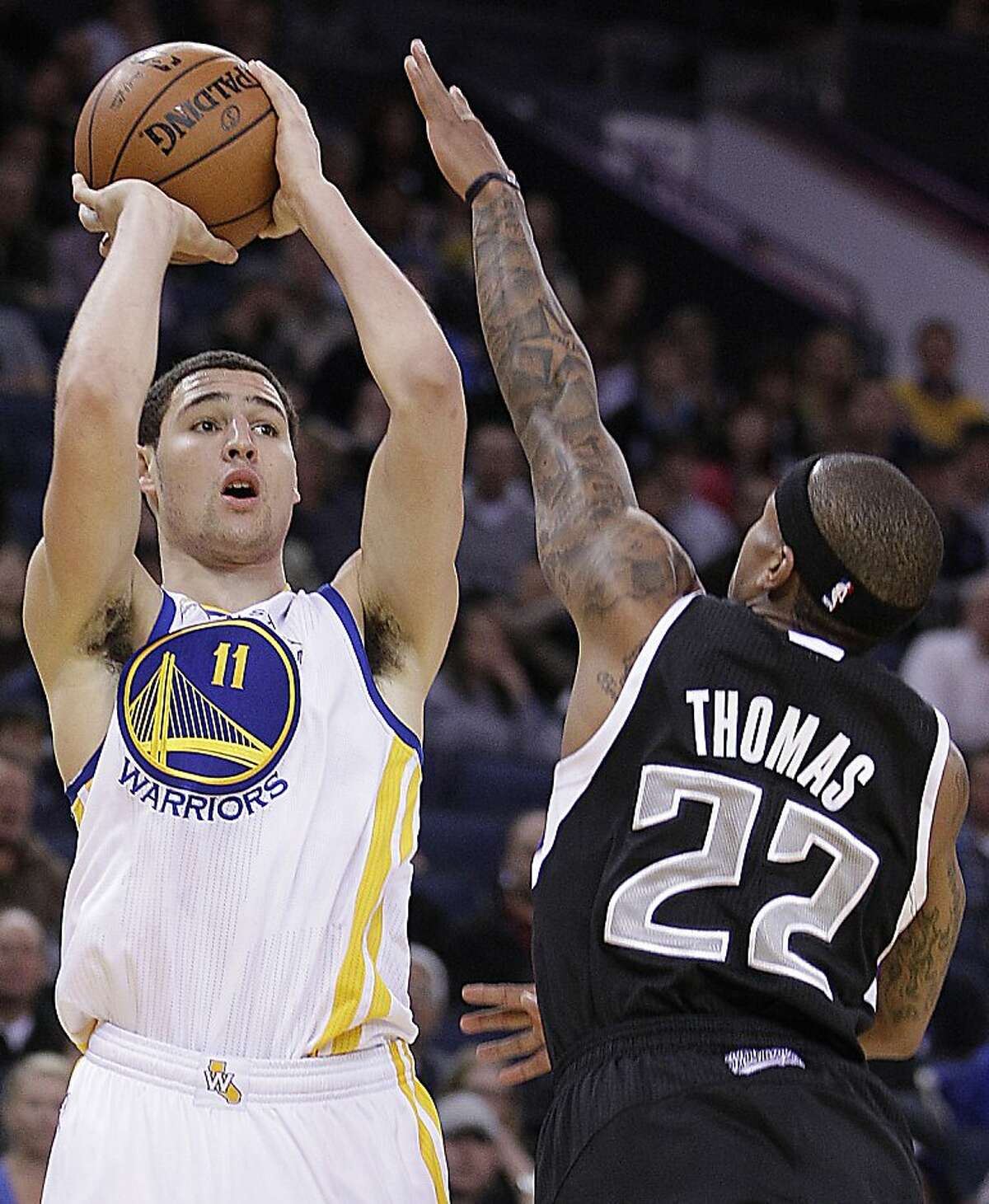 Golden State Warriors' Klay Thompson, left, shoots against Sacramento Kings' Isaiah Thomas (22) during an NBA basketball game Saturday, March 24, 2012, in Oakland, Calif. (AP Photo/Ben Margot)