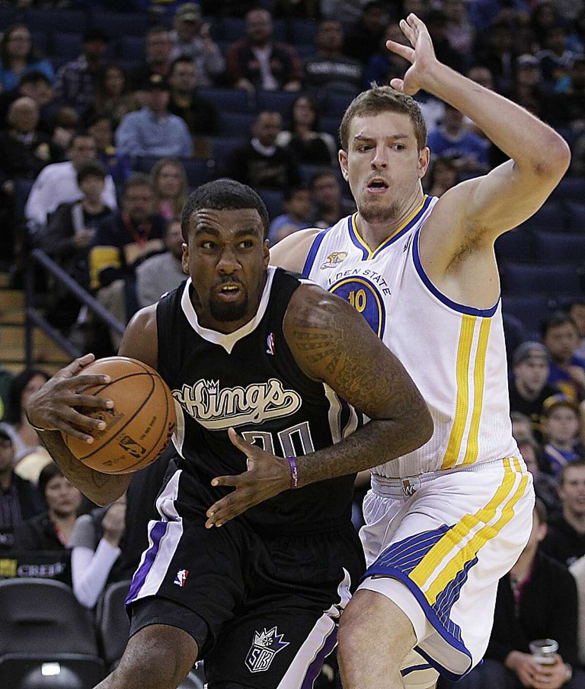 Sacramento Kings' Donte Greene, left, drives past Golden State Warriors' David Lee during the first half of an NBA basketball game Saturday, March 24, 2012, in Oakland, Calif.