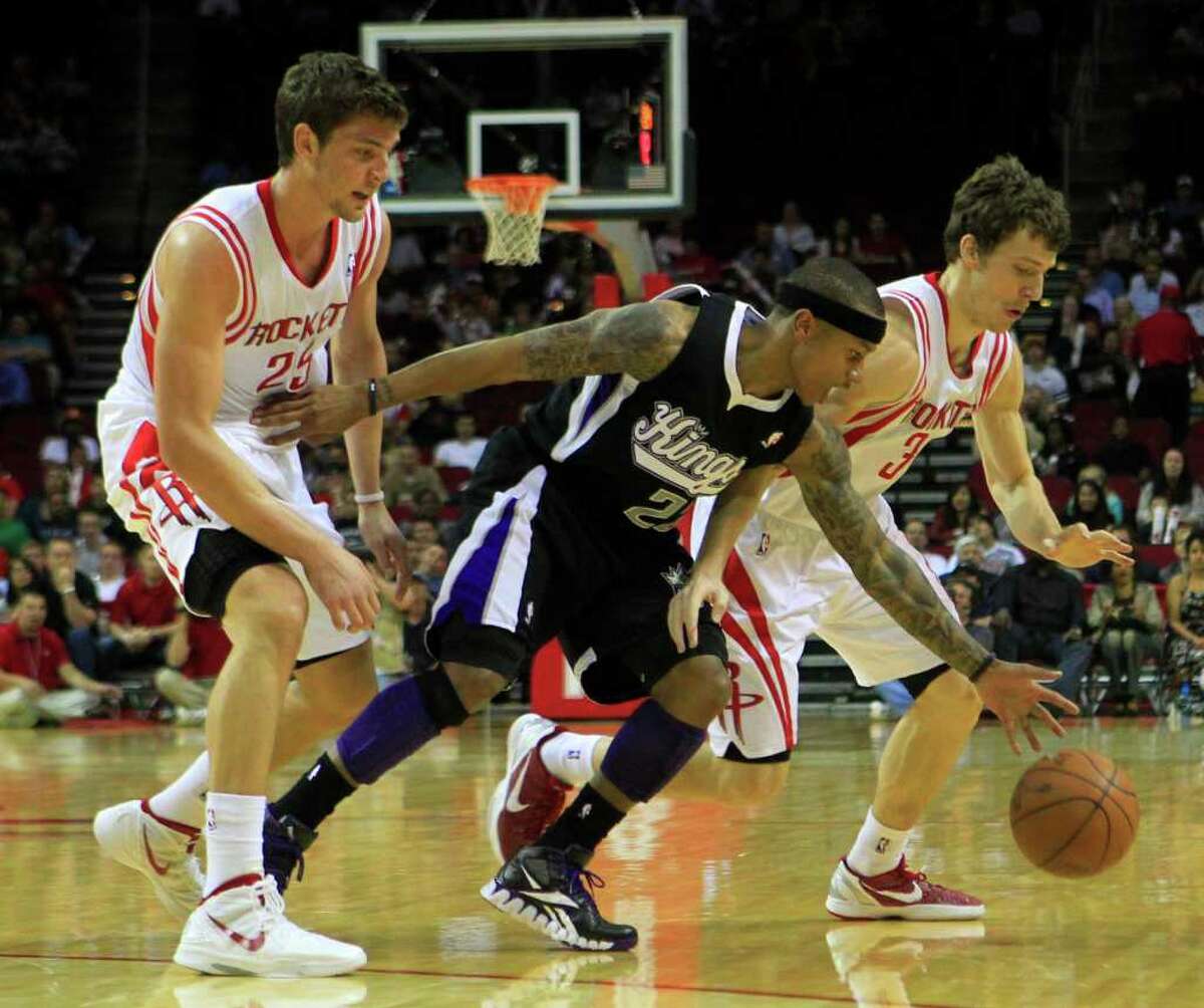Houston Rockets forward Chandler Parsons, 25, watches as Sacramento Kings point guard Isaiah Thomas, 22, knocks the ball lose from teammate Goran Dragic, 3, during the first half of a basketball game at the Toyota Center Monday, March 26, 2012, in Houston.