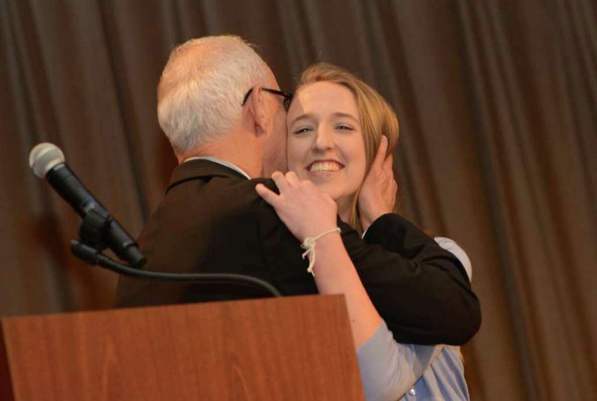Dr. Ernest Fleishman, former Superintendent of Schools, hugs Greenwich High School's Madeline Harrison, recipient of the Fleishman Service Award, during the Greenwich Public Schools annual Community Service Awards at the Old Greenwich School auditorium on Tuesday, Mar. 27, 2012.