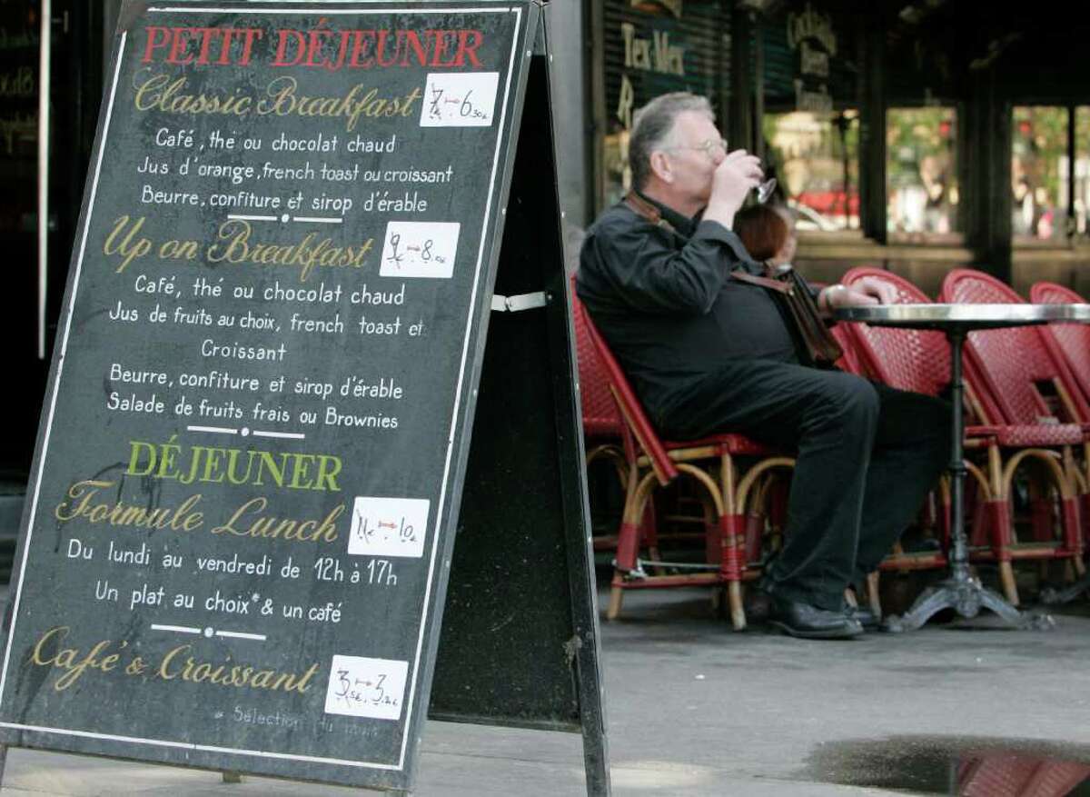 A man drinks at a cafe where prices were modified, Wednesday July 1, 2009 in Paris. France's restaurant bills could start looking a little slimmer thanks to a nearly fourfold drop in sales taxes. The measure allowing a reduction of VAT, or value-added tax, from 19.6 percent to 5.5 percent went into effect Wednesday.(AP Photo/Jacques Brinon)