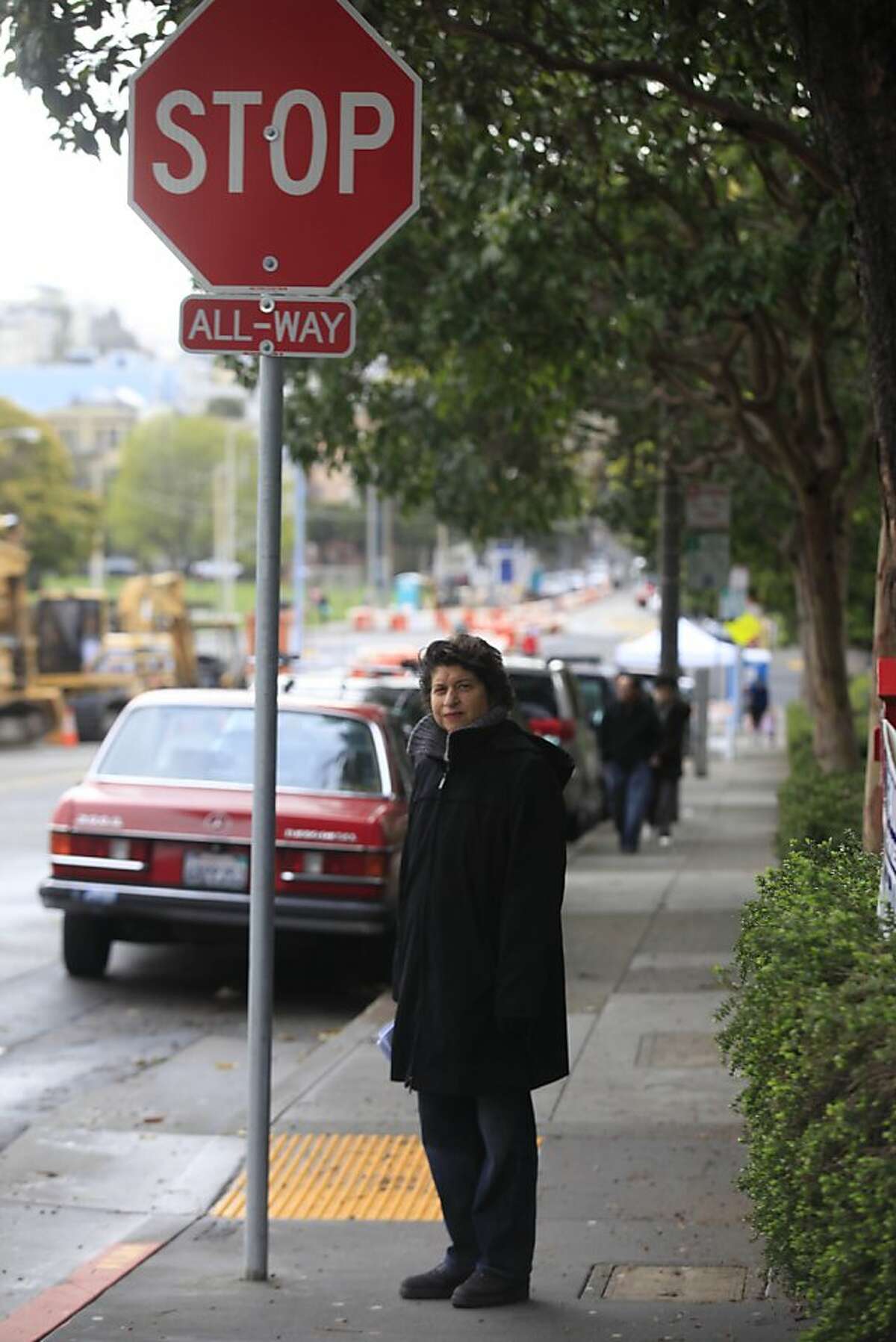 Pat Tura, chairman of Adopt a Corner program and Duboce Triangle Neighborhood Association board member, stands at the intersection at Duboce and Scott on Wednesday, March 28, 2012 in San Francisco, Calif. The groups first project was the STOP sign on Duboce Street at Scott which was hard to see due to the position of the sign and the trees surrounding it.