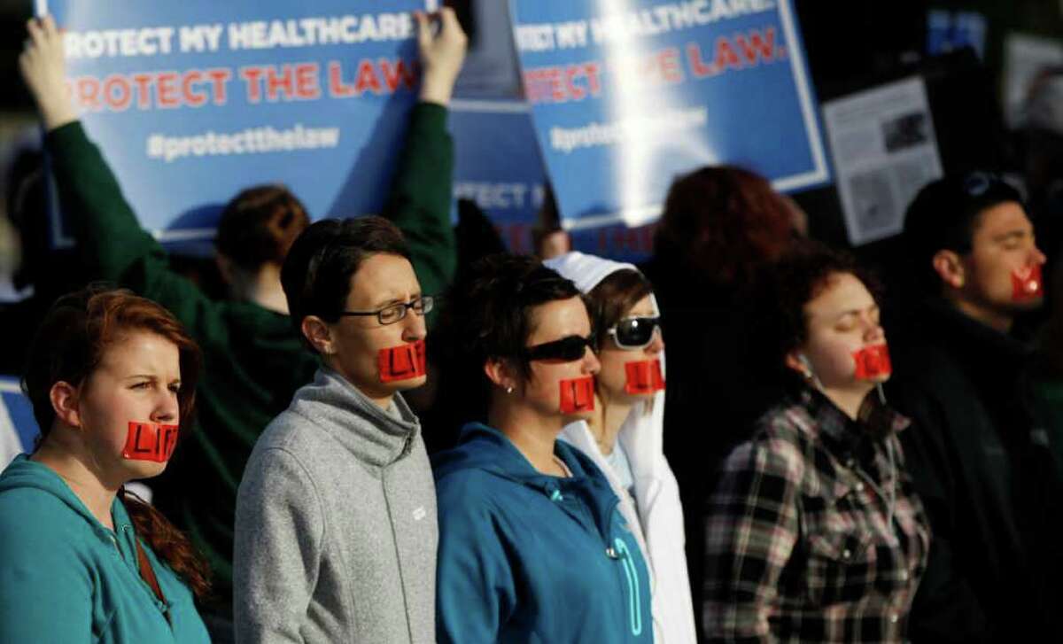 Anti-abortion demonstrators stand in front of the Supreme Court in Washington, Wednesday, March 28, 2012, on the final day of arguments regarding the health care law signed by President Barack Obama. (AP Photo/Charles Dharapak)
