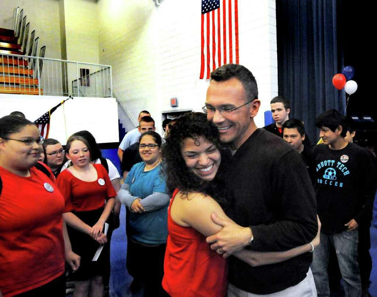 Henry Abbott Technical High School student Iris Rivera, 17, hugs teacher Andy Ipkovich during a welcome home celebration at the Danbury school Thursday, March 29, 2012. Ipkovich was given a surprise party as he returned to school after serving with the military in Afghanistan.
