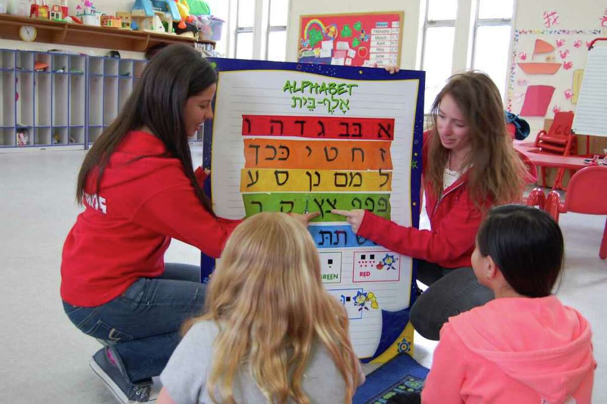 Jordana Adler and Gabi Salomon of Hebrew Wizards teach fellow students letters of the Hebrew alphabet on Thursday, March 29, 2012. Ten teens from Hebrew Wizards will travel to Atlanta this week to share their program with a Hebrew school there.