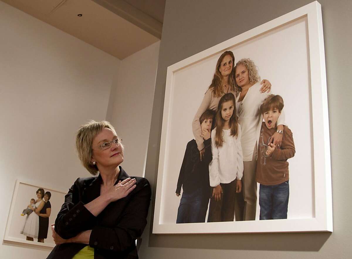 Photographer Carolyn Sherer looks at her group of photographs of lesbian families on Thursday, March 29, 2012 at the Civil Rights Institute in Birmingham, Ala.,Thursday, March 29, 2012. The photographs will be displayed thru June. Sherer says she hopes the photographs start a conversation about equality for everyone.
