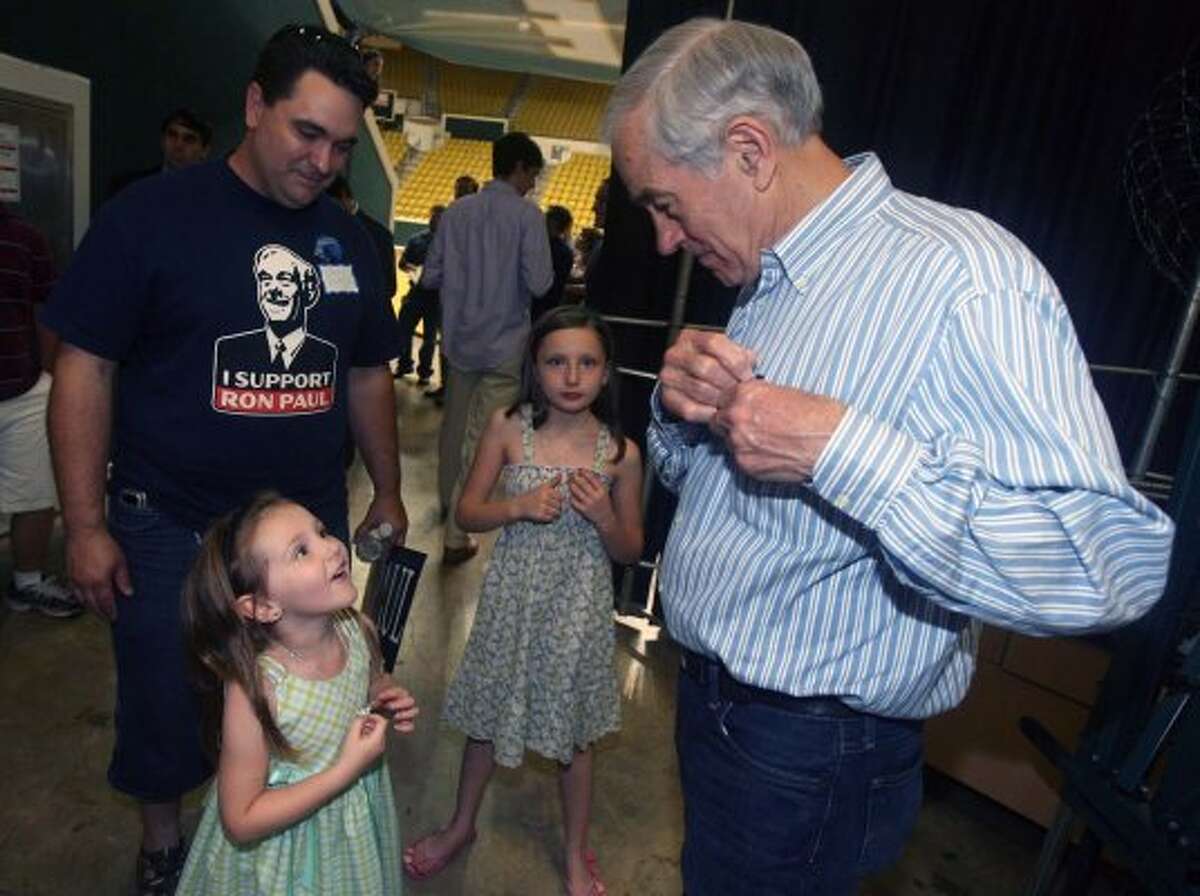 Ron Paul visits with supporters Chris Hand and daughters Arianna Hand, 5, and Skiilyn Hand, 9, after speaking during a Campus Town Hall Meeting Friday night, March 23, 2012 at Southeastern Louisiana University. (Kerry Maloney / The Associated Press)