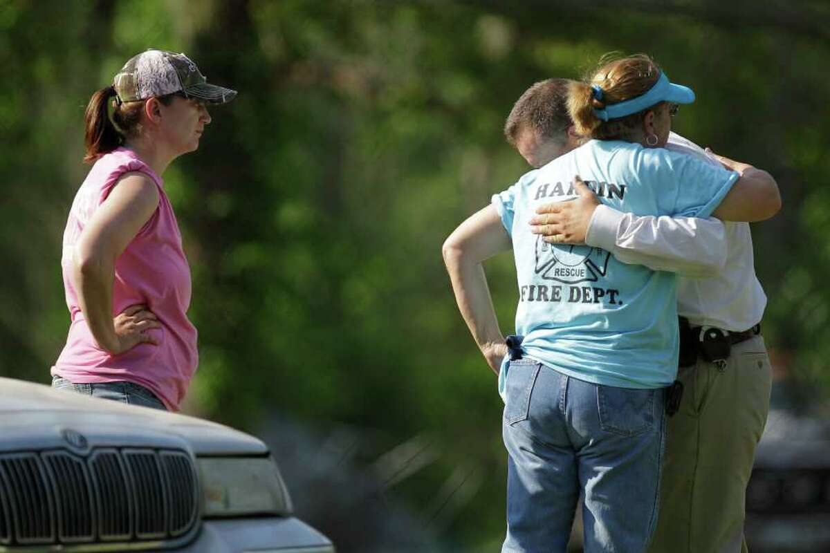 Serena Miller, left, with Cypress Lakes VFD, waits as Laura Potetz, center, with the Hardin VFD hugs Liberty County Sheriff's Captain Rex Evans after the body of 2-year-old Devon Davis was found Saturday, March 31, 2012 near the Liberty County home where he disappeared on Tuesday.