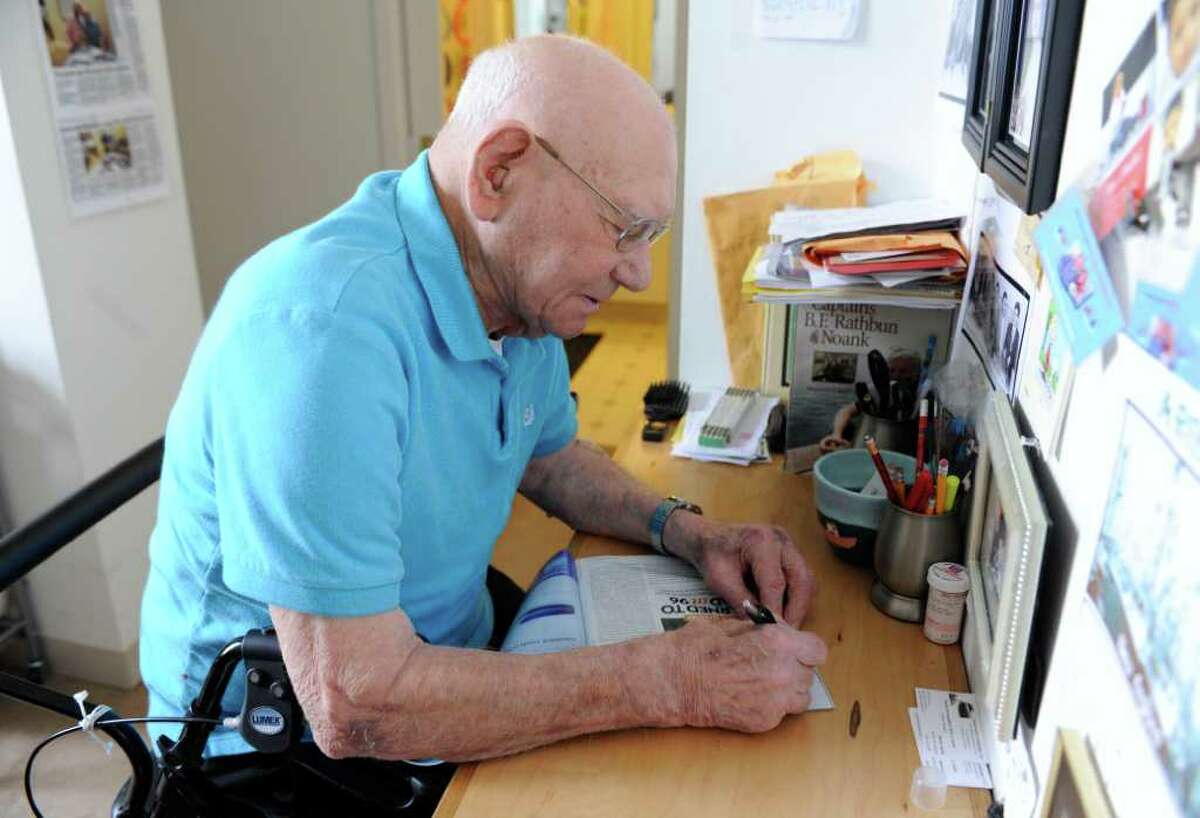 James Arruda Henry autographs a recent article in a magazine about him at his apartment in Mystic, Conn., Wednesday, March 28, 2012. The 98-year-old retired lobsterman published his autobiographical essays after learning to read and write in his 90s. (AP Photo/Jessica Hill)