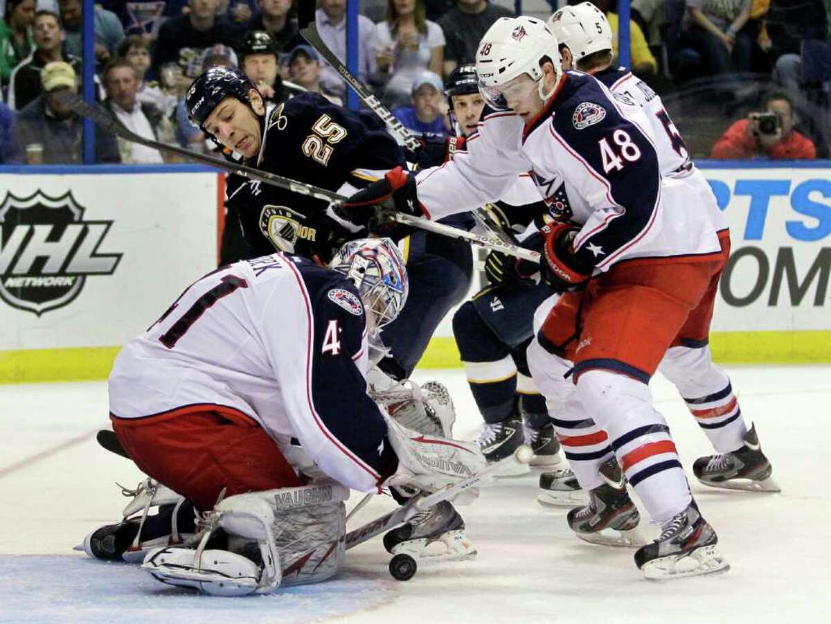 Blue Jackets rookie goalie Allen York tries to corral the puck as teammate Cody Goloubef, right, fends off the Blues' Chris Stewart.