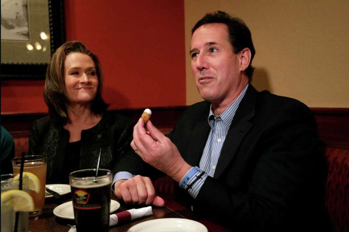 Republican presidential candidate, former Pennsylvania Sen. Rick Santorum, right, joined by his wife, Karen, eats cheese curds at a restaurant in West Bend, Wis., Sunday, April 1, 2012. (AP Photo/Jae C. Hong)