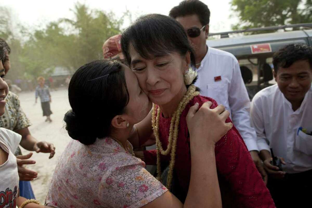 Aung San Suu Kyi receives a kiss from a supporter Sunday during a visit to a polling station in an election that might have won her a seat in government.