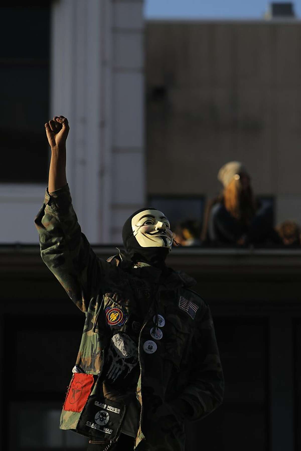 An Occupy San Francisco protester raises his fist in victory as his fellow protesters take over a building at the corner of Turk and Gough Streets in San Francisco, Calif., on Sunday, April 1, 2012, following a rally at Union Square and march up Geary.