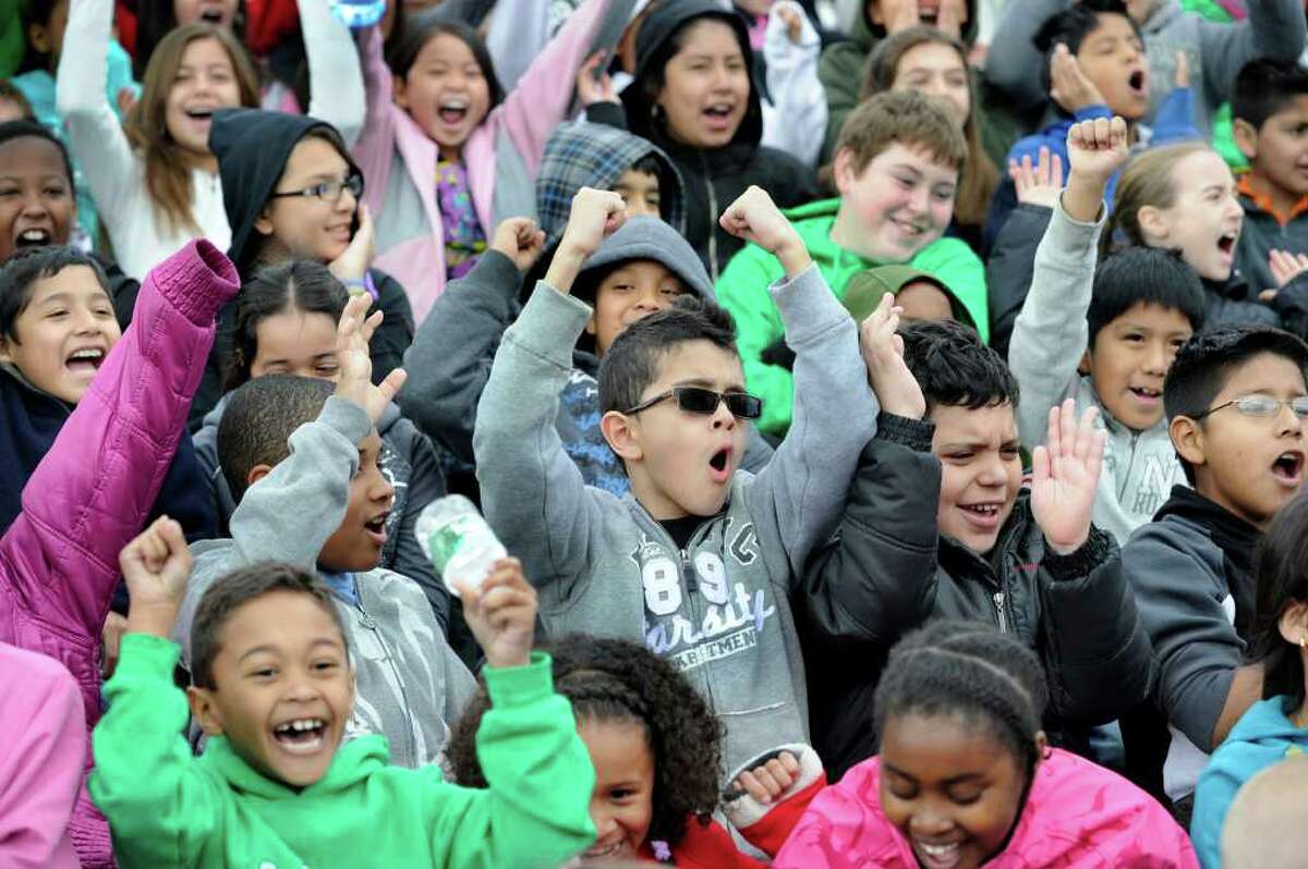 Diago Souza, 8, center, a Park Avenue School student, lets out a cheer with fellow elementary school kids prior to the start of a KidsMarathon kickoff on the track at Danbury High School Monday morning, April 2, 2012.