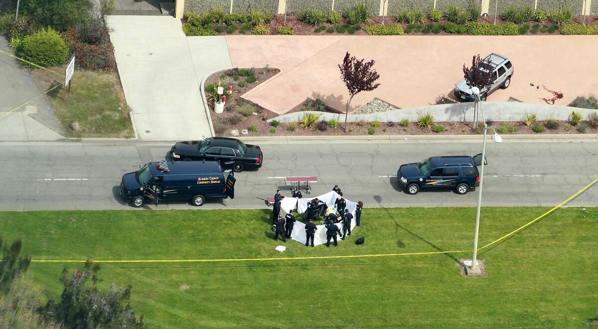 Officers from the Alameda County Sheriff Coroner Department remove the bodies from outside the Oikos University, Monday April 2, 2012, in Oakland, Calif.