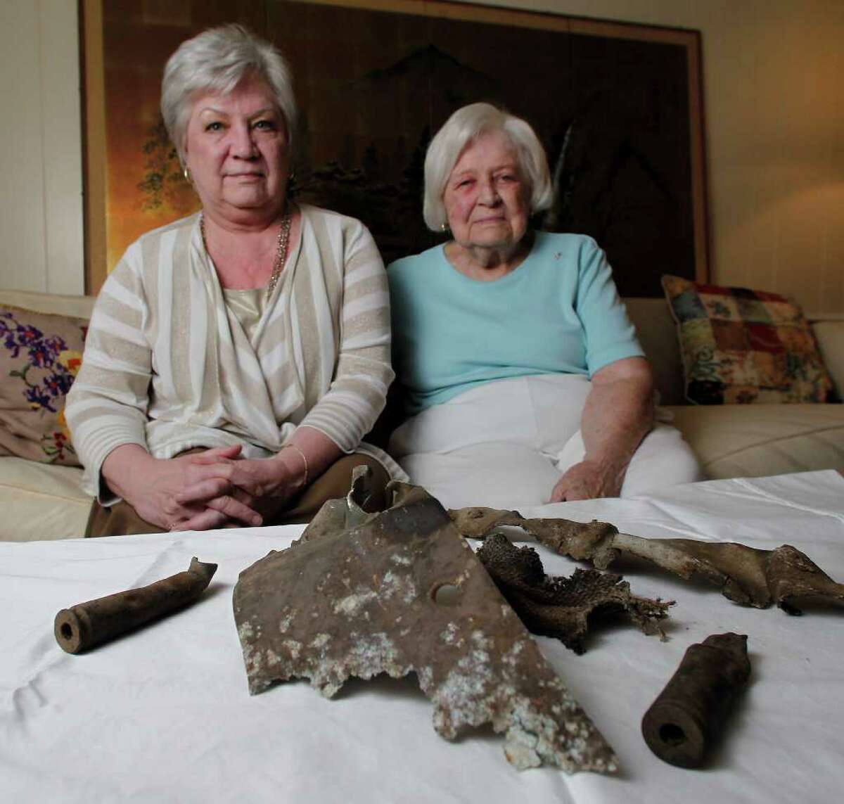 Sandra Barker, left, and her mother, Mary Martin, recently received these scraps of the crashed B-17 bomber that Martin's late husband, Kemp, navigated in World War II.