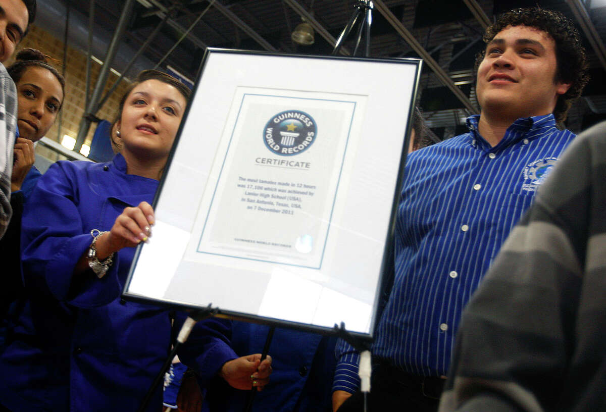 Lanier High School junior Ashley Hernandez, left, and senior David Sanchez, right, celebrate Tuesday afternoon April 3, 2012 in the school's gym during a press conference announcing that the Guiness Book of World Records certified the school's Dec. 2011 tamalada that produced 17,106 tamales as the most tamales produced in 12 hours. (William Luther/wluther@express-news.net)