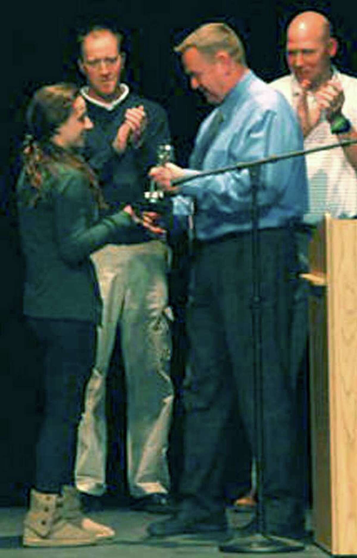 SPECTRUM/Team MVP Juliana Fusco of Green Wave girls' basketball is congratulated by program coaches, from left to right, Giles Vaughan, Bill Kersten and Keith Lipinsky during the March 26, 2012 winter sports awards ceremony at New Milford High School. Courtesy of Lisa Fucso