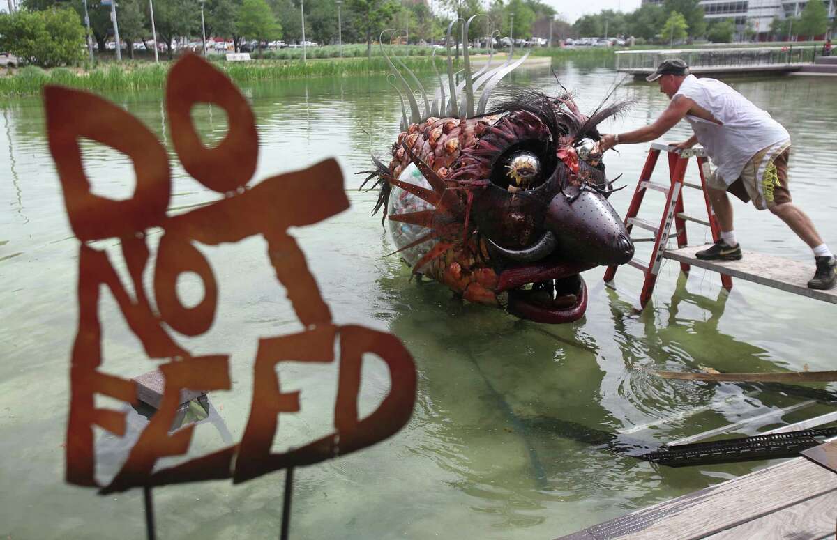 Eco Artist Mark Bradford assembles "NOMO" Trash Fish sculpture in the lake at Discovery Green on Thursday, April 5, 2012, in Houston.
