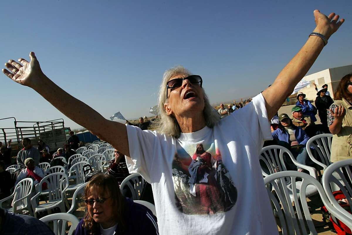 An Evangelist Christian pilgrim raises her arms and shouts the Lord's praises during prayers before being baptized in the waters of the Jordan River January 11, 2007 near Jericho in the West Bank. About 100 pilgrims, mainly from the U.S., participated in a ceremony at the place where Christians believes that Jesus was baptized by John. (Photo by David Silverman/Getty Images)