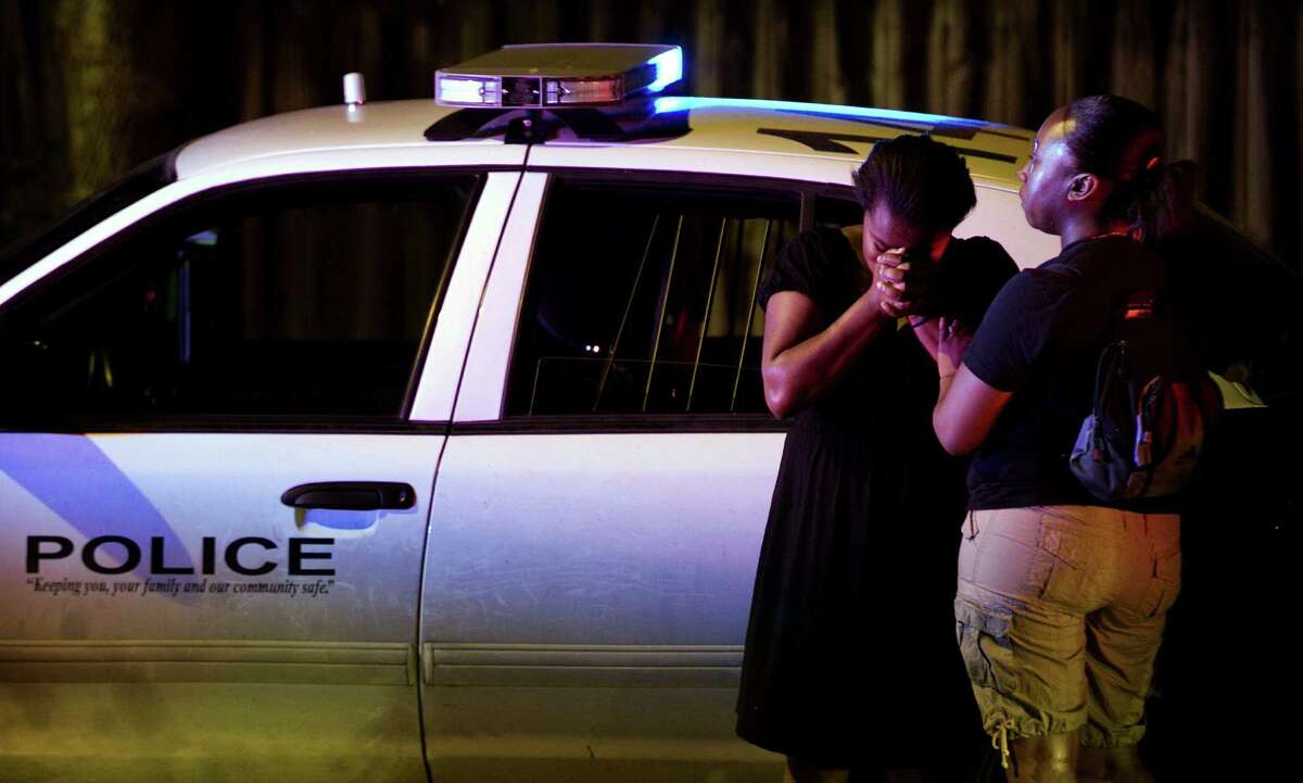 A woman cries at the scene of a police shooting on Thursday April 5, 2012 in Austin, Texas. An Austin police officer fatally shot a man after a traffic stop that authorities said quickly escalated. (AP Photo/Austin American-Statesman, Jay Janner) MAGS OUT; NO SALES; INTERNET AND TV MUST CREDIT PHOTOGRAPHER AND STATESMAN.COM