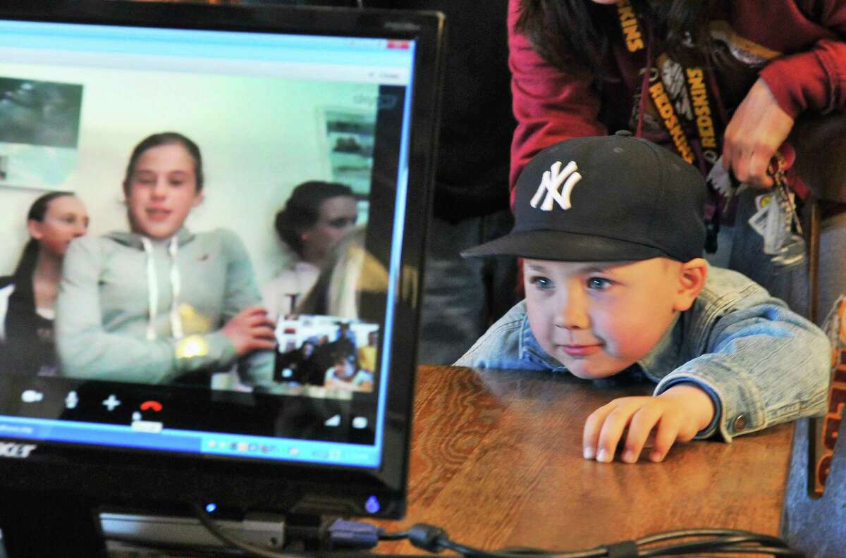 Five-year-old Andrew Putnam speaks with big sister Kortnee Phillips,15, on screen, via a Skype call with Rensselaer Middle School student students currently on Half Moon exchange to Dutch school Bornego College in Heereveen, the Netherlands back to family members at the Half Moon ship offices in Albany Friday April 5, 2012. (John Carl D'Annibale / Times Union)