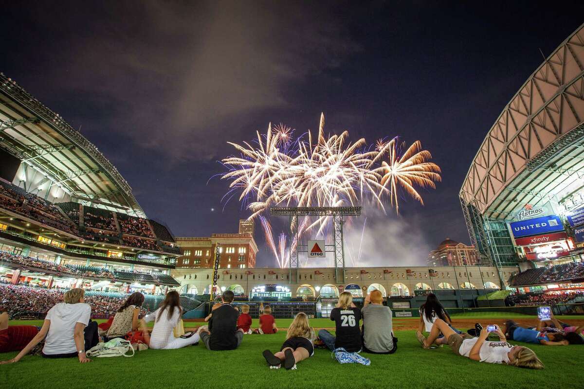 Astros players families watch from the field as fireworks explode over the stadium after the Astros season opener against the Colorado Rockies at Minute Maid Park on Friday, April 6, 2012, in Houston.
