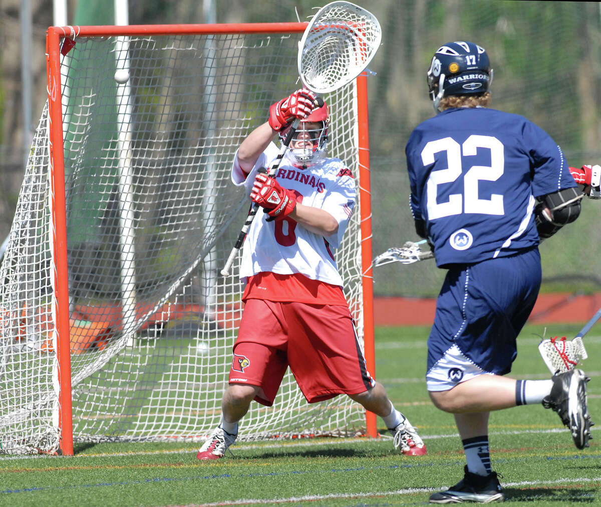 At right, Michael Slaughter # 22 of Wilton High School scores on Greenwich goalie Ryan Fisher during the boys high school lacrosse match between Greenwich High School and Wilton High School at Greenwich, Saturday, April 7, 2012. Wilton defeated Greenwich 13-9.