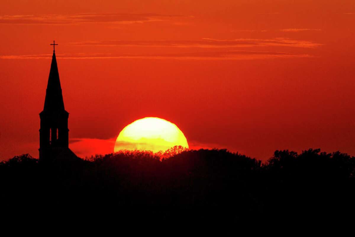 The sun sets behind St. Mary's Church in High Hill, Texas.