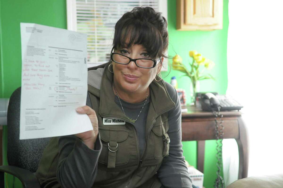 Time Warner Cable customer Michelle Manchester holds a copy of her cable bill from February of this year during an interview on Thursday, April 5, 2012 in Clifton Park, NY. Manchester says that she has been billed for movies she did not rent, or billed multiple times for renting the movie one time. She also takes issue with the bill just listing "premium movie" and not the title of the movie, because she says then there is no way to know if she did rent that movie or is being wrongly billed for a movie title she did not rent. (Paul Buckowski / Times Union)