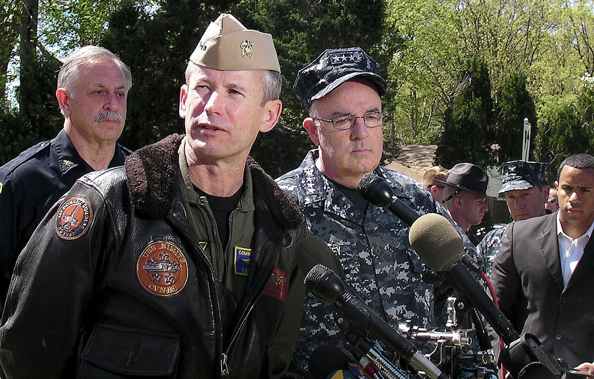 Rear Adm. Ted Branch, front left, and Adm. John Harvey, commander of U.S. Fleet Forces Command, speak with reporters Saturday, April 7, 2012, near the scene of a Navy jet crash in Virginia Beach, Va. The Navy and civilian authorities have just begun their investigation into the crash of the F/A-18D fighter that hit the complex on Friday.