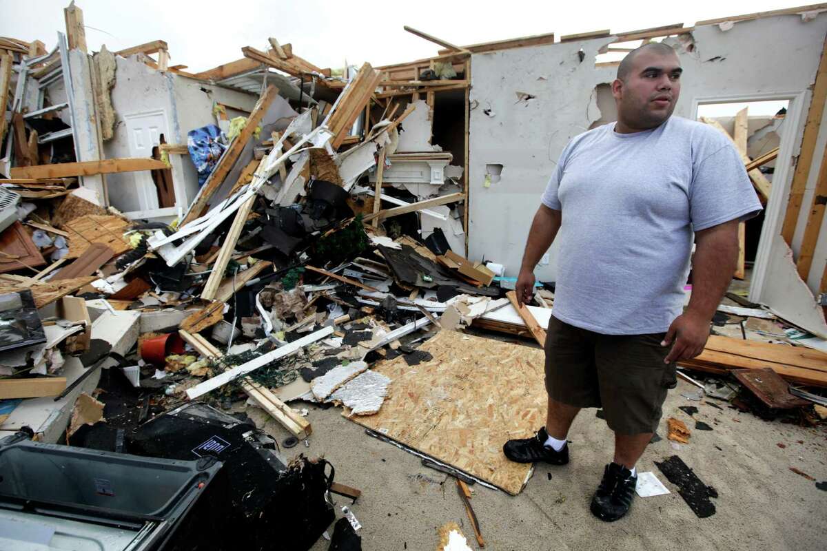 FILE - In this April 4, 2012 file photo, Juan Ventura Jr., stands in the middle of his tornado-damaged home as he works to save personal items from the destruction in Forney, Texas. Ventura held out little hope he would ever see his brindle boxer Oscar, that had been in the backyard when the devastating twister swept through Tuesday, leaving no sign of the pooch or his dog house. But Ventura was reunited with the dog Thursday after the family that found him posted his picture on social media sites and a third party made the connection between a media interview with Ventura and the boxer?s picture. (AP Photo/Tony Gutierrez, File)