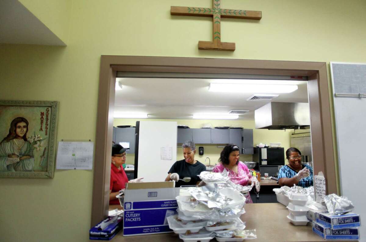 Volunteers serve dinners on Good Friday at St. Maria Goretti Church, which has been cooking up Lenten fish fries for 15 years, in New Orleans, where the Friday fish fry during Lent has become a major event.