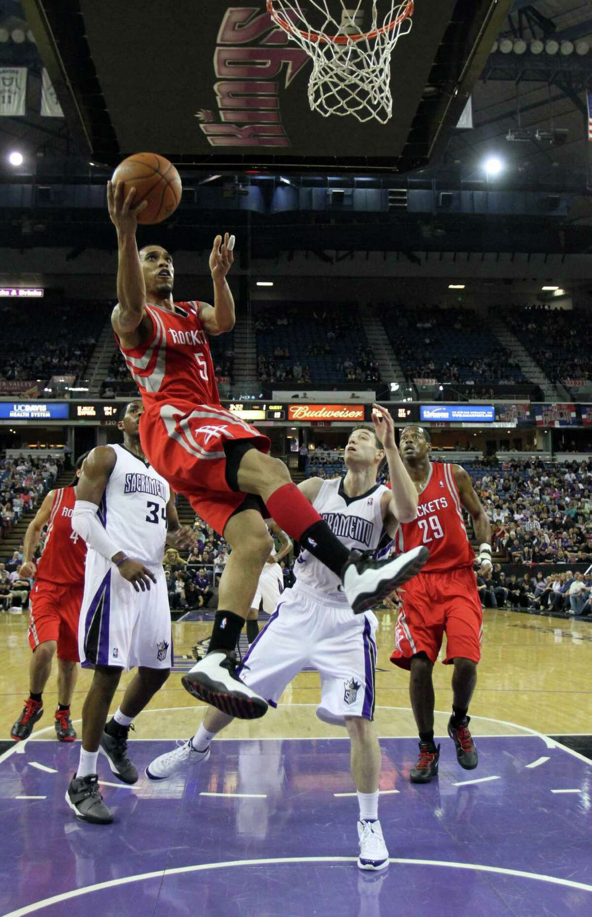 Houston Rockets guard Courtney Lee, left, goes to the basket against Sacramento Kings guard Jimmer Fredette, right, during the first quarter of an NBA basketball game in Sacramento, Calif., Sunday, April 8, 2012.(AP Photo/Rich Pedroncelli)