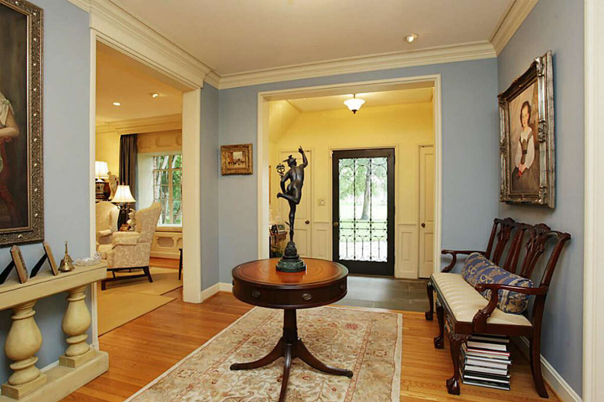 The entryway of the home features hardwood floors and a sitting area.