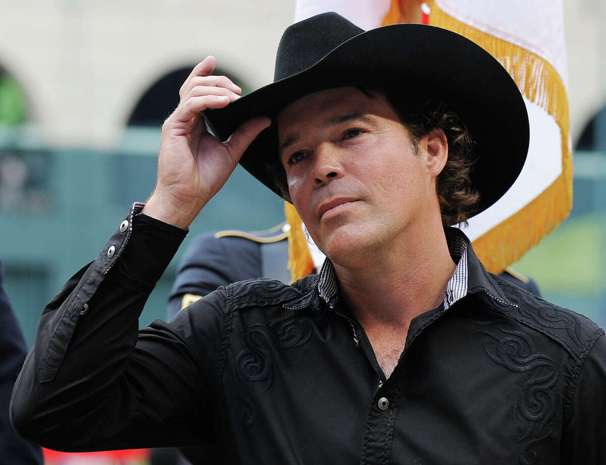 Country western singer Clay Walker tips his cap to the crowd before removing it to sing the national anthem during opening day ceremonies before the Houston Astros baseball game against the Colorado Rockies Friday, April 6, 2012, in Houston.