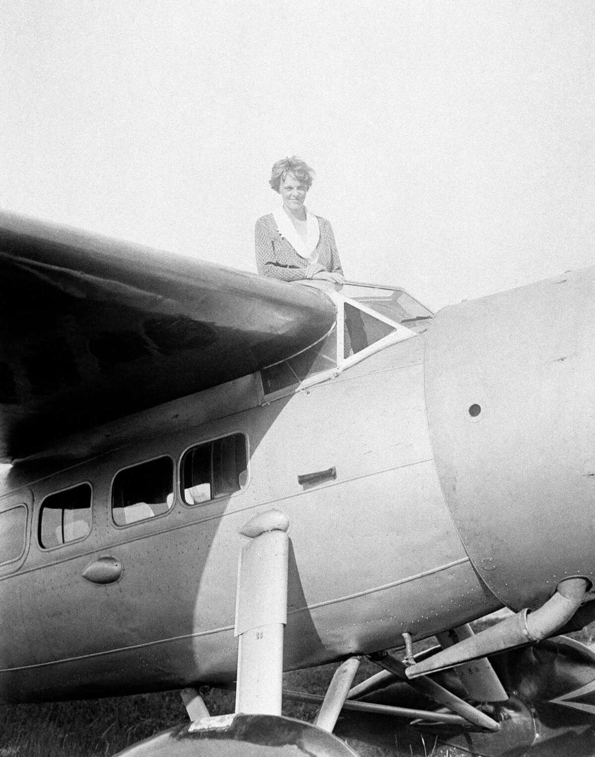 FILE - In this undated photo, Amelia Earhart, the first woman to cross the Atlantic Ocean by plane sits on top of a plane. Secretary of State Hillary Rodham Clinton is wading into one of the 20th century?s most enduring mysteries: the fate of American aviator Amelia Earhart, disappeared over the South Pacific 75 years ago. Clinton is meeting March 20, 2012, with historians and scientists from The International Group for Historic Aircraft Recovery, which will launch a new search in June for the wreckage of Earhart?s plane off the remote island of Nikumaroro. (AP Photo)