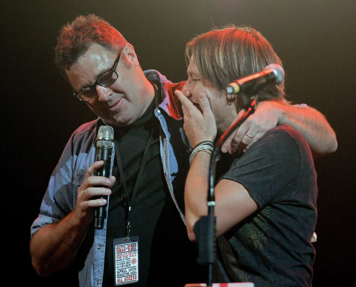 Keith Urban, right, is congratulated by Vince Gill, left, after it was announced that Urban has been selected to become a member of the Grand Old Opry during the All for the Hall concert on Tuesday, April 10, 2012, in Nashville, Tenn. The concert is a benefit for the Country Music Hall of Fame and Museum. (AP Photo/Mark Humphrey)