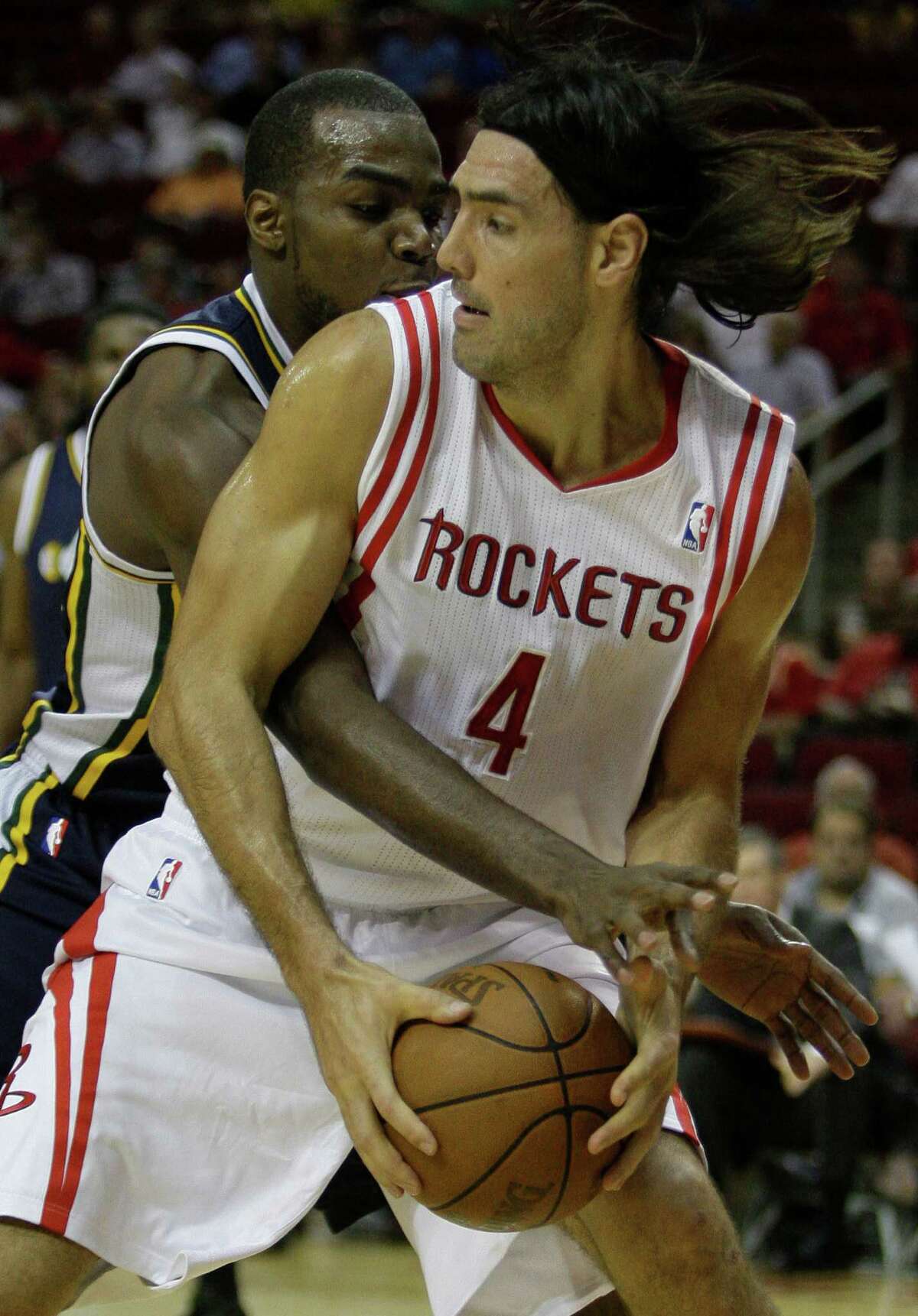 Utah Jazz's Paul Millsap, left, and Houston Rockets' Luis Scola, right, tangle over ball during the first quarter of NBA game at Toyota Center Wednesday, April 11, 2012, in Houston.