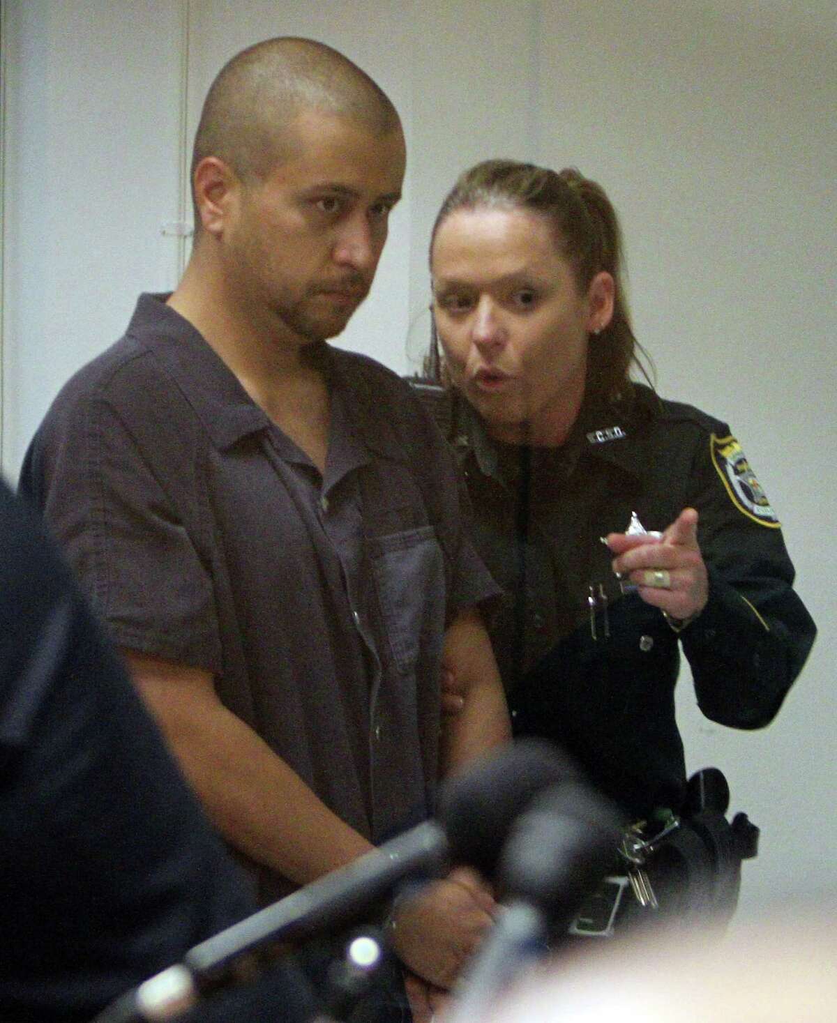 George Zimmerman is directed by a Seminole County Deputy during a court hearing Thursday, April 12, 2012, in Sanford, Fla. Zimmerman has been charged with second-degree murder in the shooting death of the 17-year-old Trayvon Martin. (AP Photo/Gary W. Green, Orlando Sentinel, Pool)