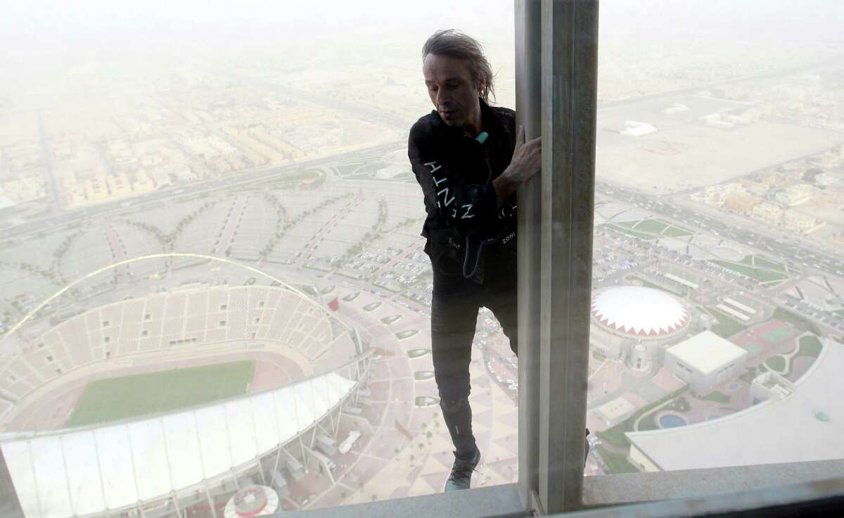 Alain Robert, who has been dubbed the 'French Spiderman', climbs 300 meters up The Torch hotel in Doha on April 12, 2012. Robert, who has been scaling tall buildings since the age of seven took 75 minutes to complete his first climb in Qatar of the hotel that was built for the 2006 Asian Games in the shape of an Olympic torch. AFP PHOTO/FAISAL AL-TAMIMI