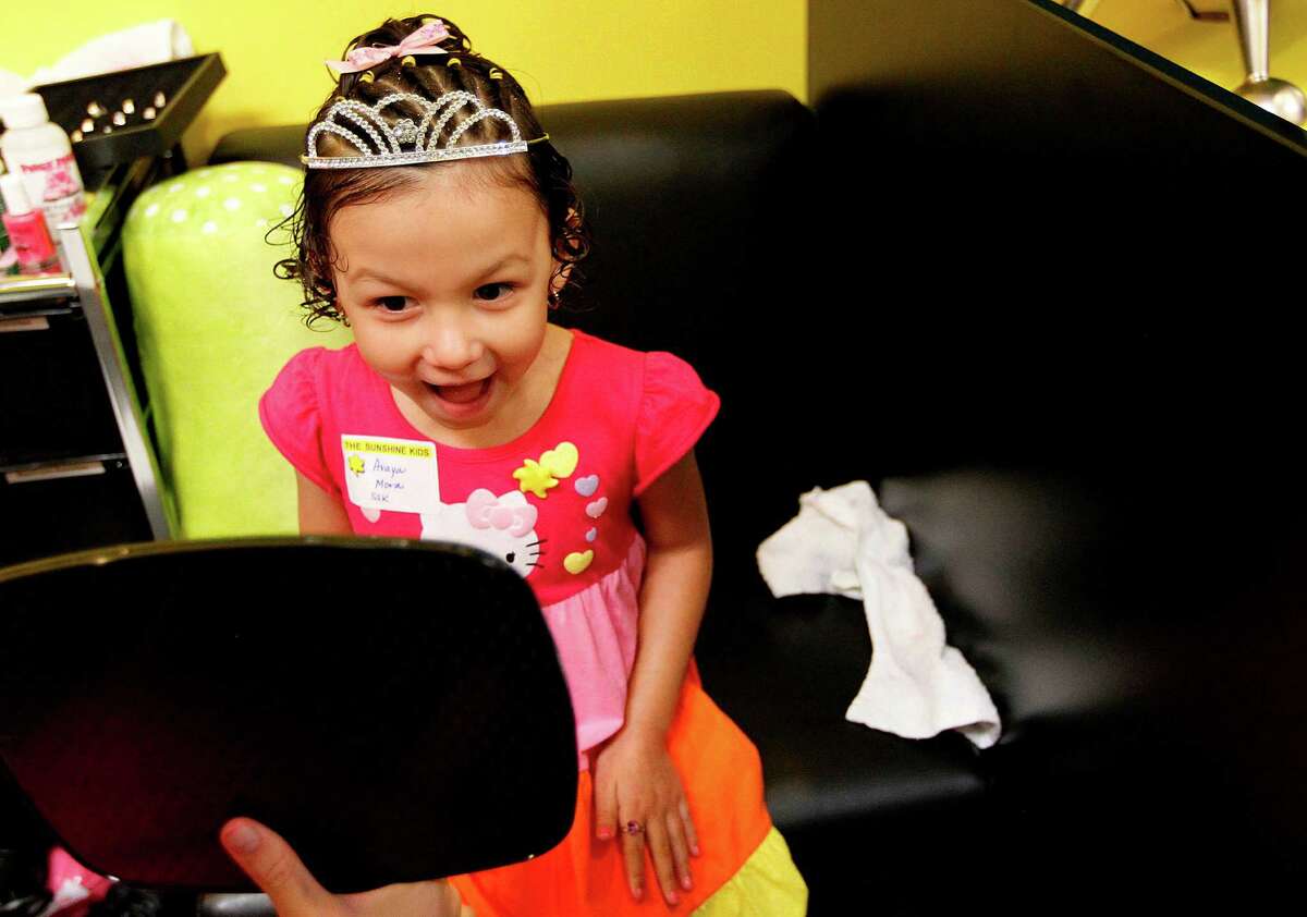 Avaya Mora, 5, smiles when she sees herself wearing a princess' tiara during a "Princesses for a Day" event. Six Sunshine Kids are princesses for a day as they get hair styling, manicures, and wear princess dresses during a karaoke style Princess Party. The girls also got to meet Disney Princess characters, then to see Disney On Ice: Dare to Dream.  ( Mayra Beltran / Houston Chronicle )