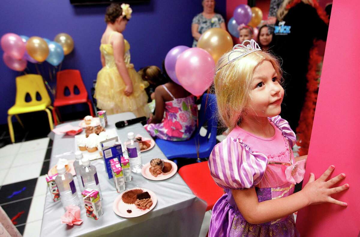Avaya Mora, 5, dressed in a princess costume looks at other princess dresses as she enjoys the "Princesses for a Day" party.