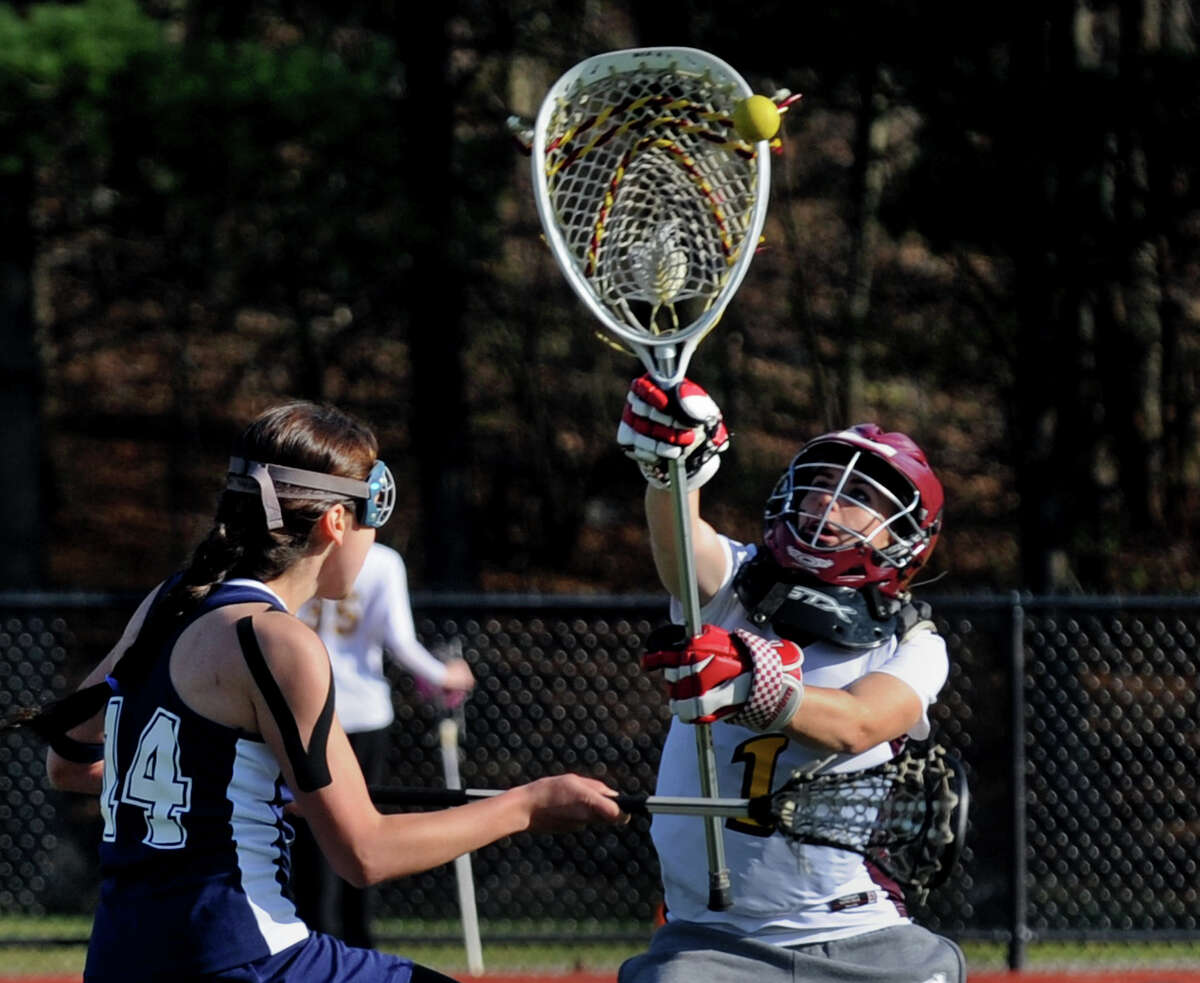St. Joseph's #1 Cassie Collins deflects a goal attempt by Lauralton Hall's #14 Allison Carey during girls lacrosse action in Trumbull, Conn. on Thursday April 12, 2012.