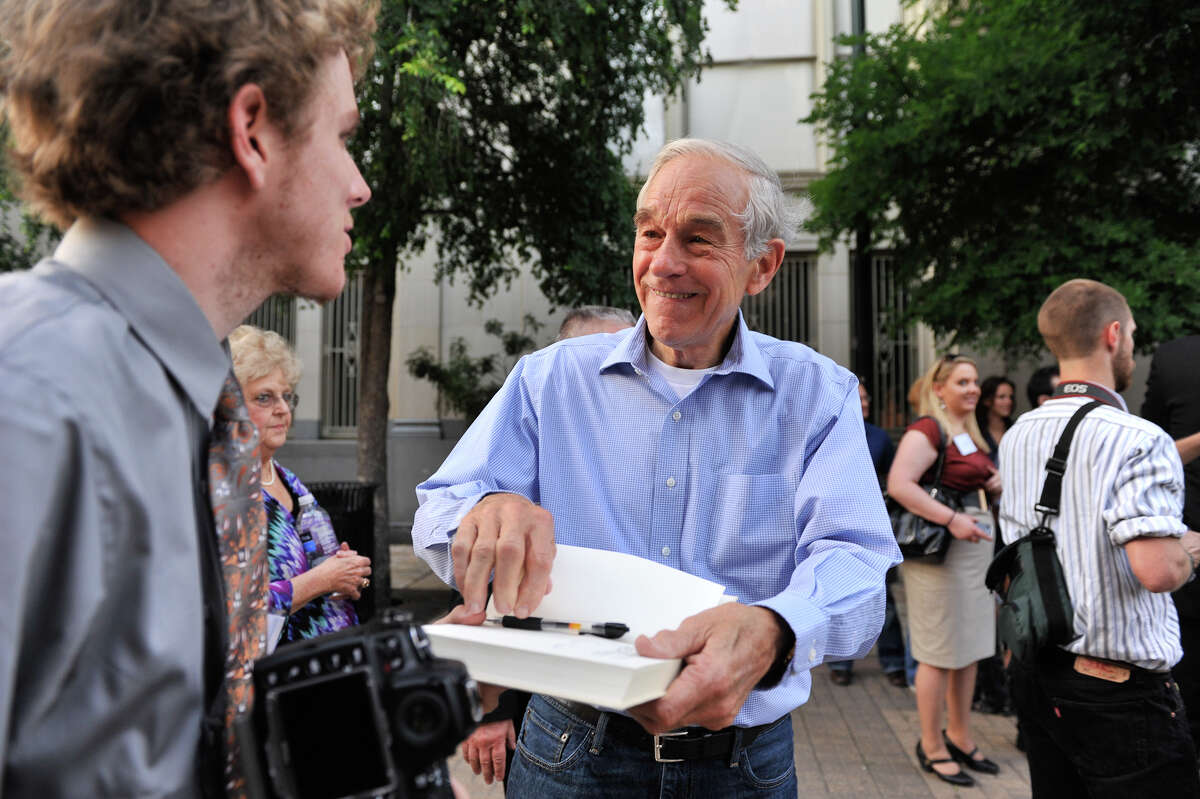 GOP presidential candidate Ron Paul signs a copy of his book after speaking to supporters at a rally in Main Plaza.