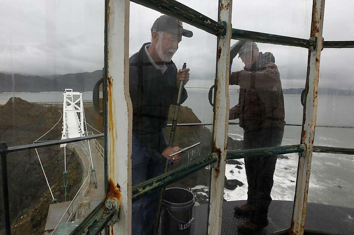 Mike Madden and Jim Brainerd clean window panes of the Point Bonita lighthouse in Sausalito, Calif. on Tuesday, April 10, 2012, in preparation for this weekend's reopening of the lighthouse and newly rebuilt suspension foot bridge (left).