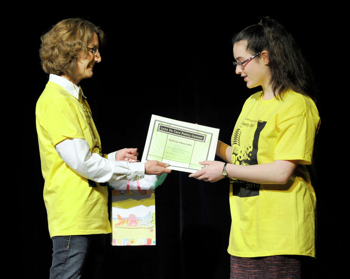 English teacher Andrea Norem-Thompson, left, presents Sylvia Onorato, 15, a freshman at New Milford High School, with the first Lynn De Caro Memorial Award for Poetry at the Poetry Slam at New Milford High School on Friday, April 13, 2012.
