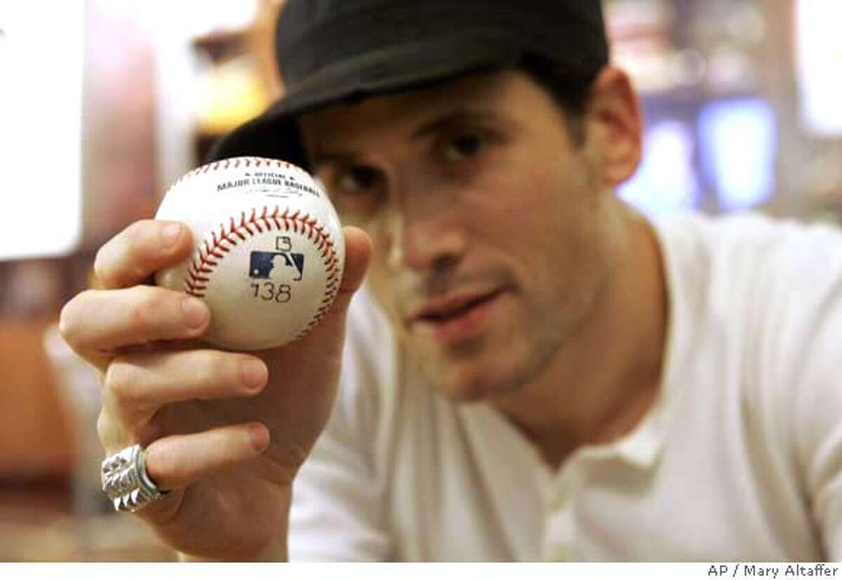 Fashion designer Marc Ecko poses with Barry Bonds' record-breaking home run baseball Monday, Sept. 17, 2007, in New York. Ecko was the winning bidder in the online auction for the ball from Bonds' 756th career home run, and has announced that it is now in the public's hands. Ecko announced Monday he was taking votes on whether to give the ball to the Hall of Fame, brand it with an asterisk or blast it into space. (AP Photo/Mary Altaffer)